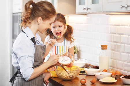 幸福的家庭在厨房里。母亲和孩子烘烤曲奇饼
