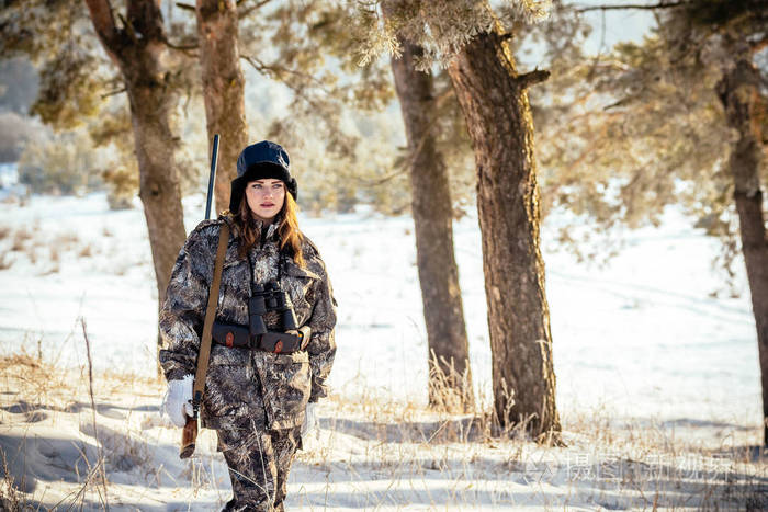 女猎人在伪装衣服准备去狩猎,枪