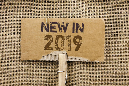写笔记显示新的在2019年。商业照片展示新的时代的最新年度季节即将到来的现代写在纸板件持有的黄麻背景剪辑