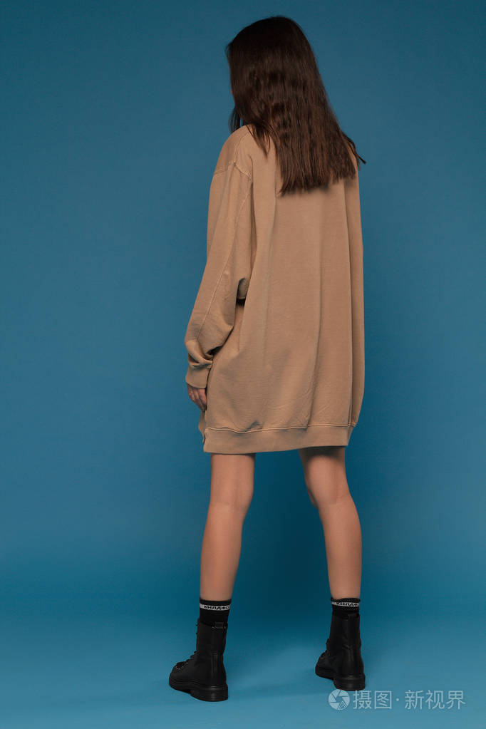 蓝色背景时尚鞋的女孩与美丽的腿