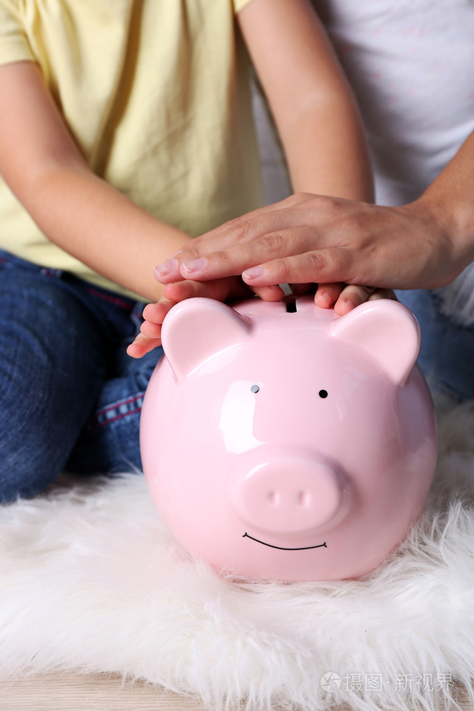 小女孩用她妈妈和猪扑满特写