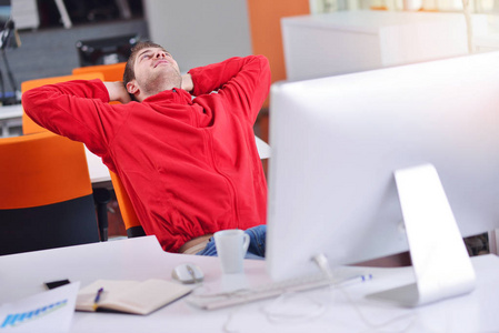 快乐的年轻商业男人在现代办公室计算机上工作