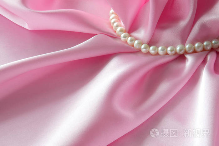 光滑优雅玫瑰丝绸背景与珍珠，美丽的丝绸窗帘。文本的空间