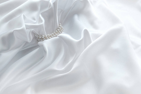 用丝绸和珍珠的豪华白色背景。美丽的丝绸窗帘