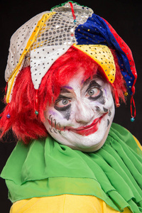 可怕的小丑，一个可怕的化妆和帽子在 b 边笑边