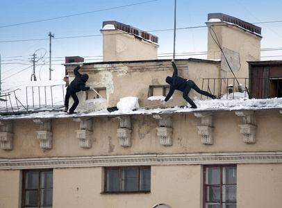 脱掉雪和冰柱从屋顶。清洁工作，而没有保险的工作。俄罗斯圣彼得堡