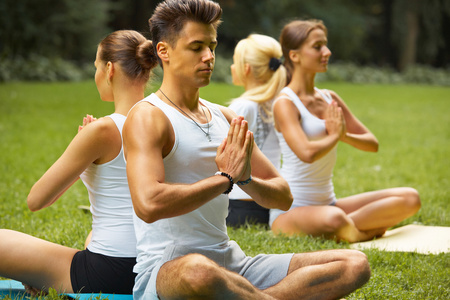 瑜伽课。一群人在夏天公园冥想
