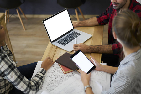 在草图和现代 macbook 计算机上使用带有模拟区域的数字平板电脑的年轻男女专业人员的裁剪图像在您的广告文本信息或网站上显示空