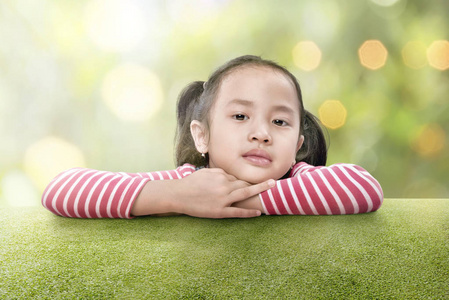 快乐亚洲女孩靠在户外的绿草上