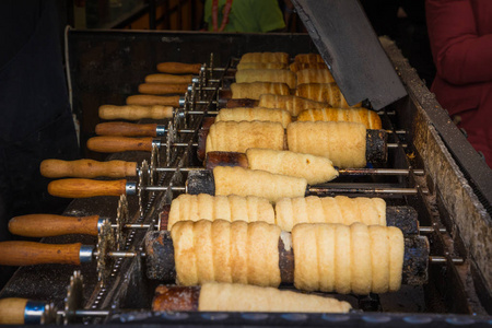 传统的捷克甜 Trdelnik 在热煤专用木串上的处理