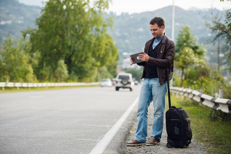 人站在一起等车或的士的数字平板电脑.搭便车照片