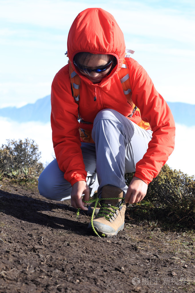 女性的徒步旅行者绑鞋带