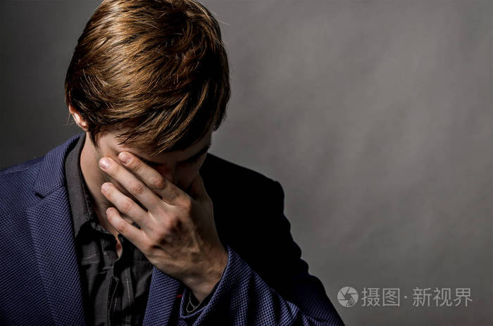 年轻的商人在一套西装伤心和感觉痛在头黑暗手拿着手指visiblehe坏的