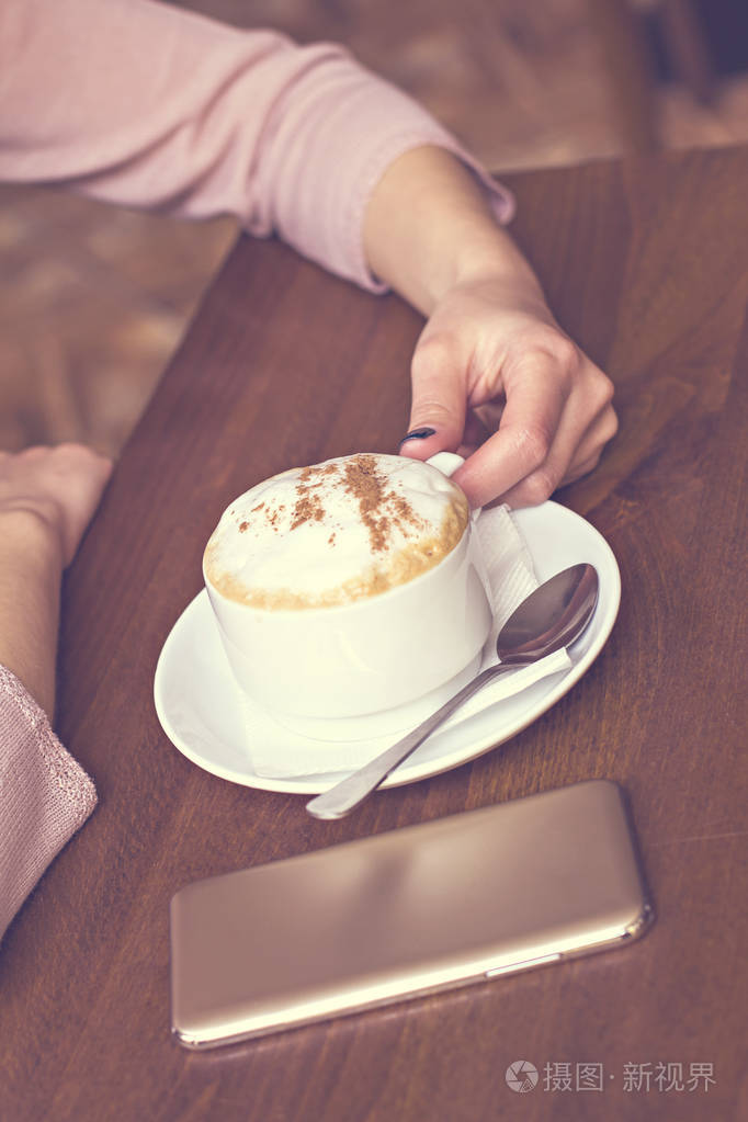 女性手捧一杯咖啡卡布奇诺