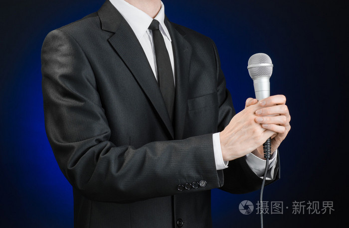 商务和演讲主题穿黑色西装的男人拿着一个微型面罩