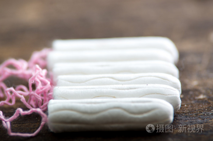 干净的白色卫生棉躺在木制表面