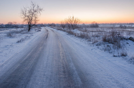 冬季场景观灯光柔和的夕阳光雪域景观场景在温暖的色调与积雪场和树木上的霜树木覆盖着霜冻