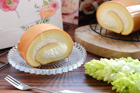 在玻璃板上美味奶油瑞士卷照片