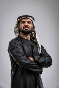 英俊高大的阿拉伯胡子男子模型在脱掉衬衫摆在户外反对皇家铁门.