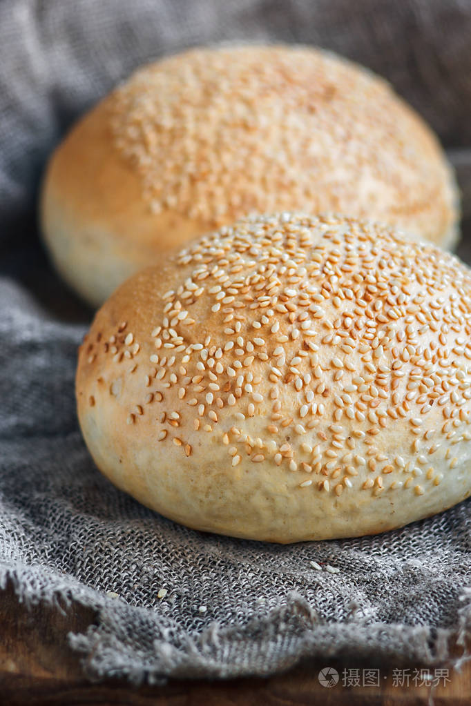 圆面包, 芝麻面包, 面包卷.美味的汉堡面包, 芝麻木, 粗麻布的背景.