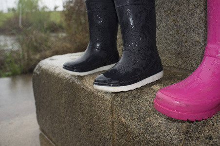 蓝色雨鞋儿童雨鞋花岗岩块下雨天的细节照片
