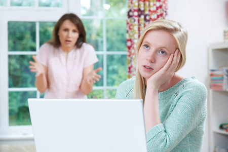 母亲跟十几岁的女儿争论在线活动