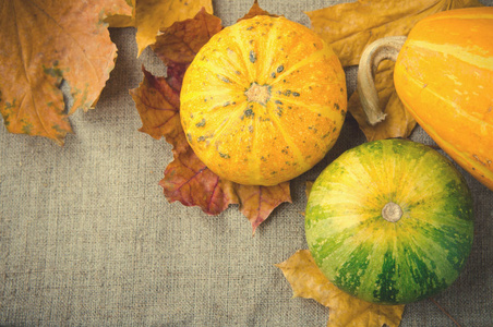 秋天的南瓜和秋天的落叶，对亚麻的背景装饰南瓜