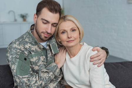 男人的肖像在军事制服拥抱母亲在家里