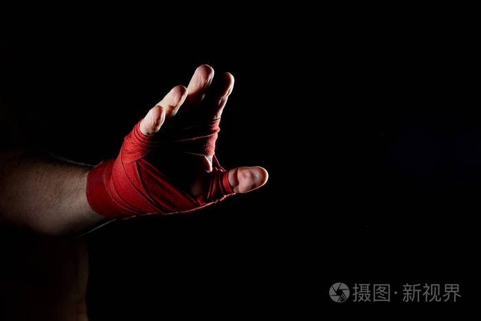 一个拳击手红色绷带在他的手上孤立的黑暗模糊背景特写
