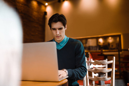 商人使用他的笔记本电脑在咖啡馆