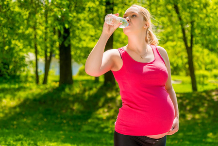 孕妇喝新鲜的水从瓶子里的肖像