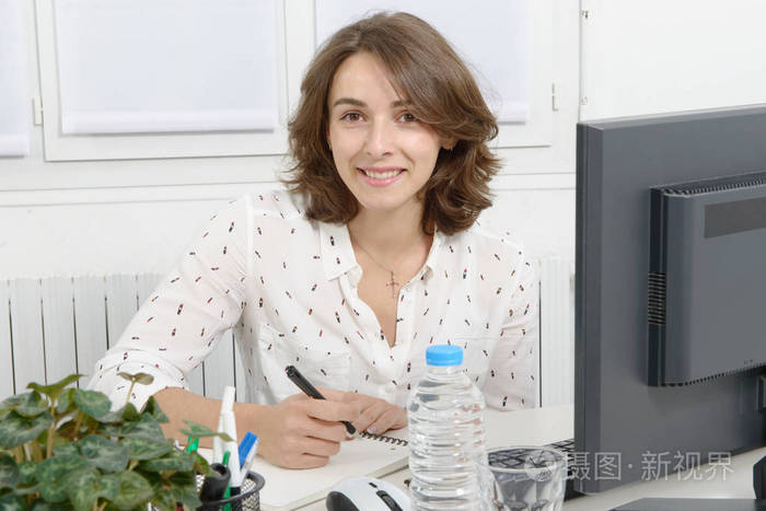 在办公室里的 pc 上工作的年轻漂亮商界女强人