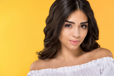 美丽的黑发女孩的肖像看着相机, 孤立的黄色照片