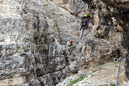 攀爬通过 Ferrata 塞韦里诺 Casara 与 Sexten 多洛米蒂山，南蒂罗尔，意大利在桥的人