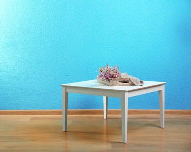 小桌子上面放着花蓝色墙背景图片