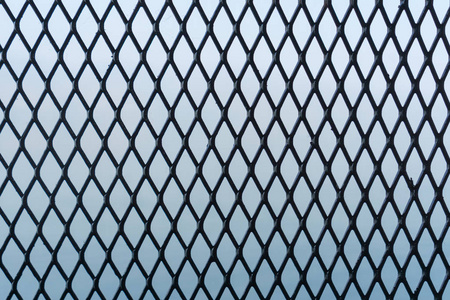 蓝色背景上的铁栅栏或金属网照片