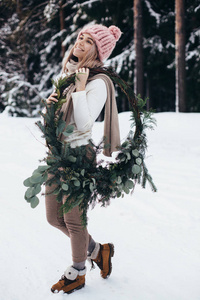 冬天森林里戴着圣诞花环的金发女郎