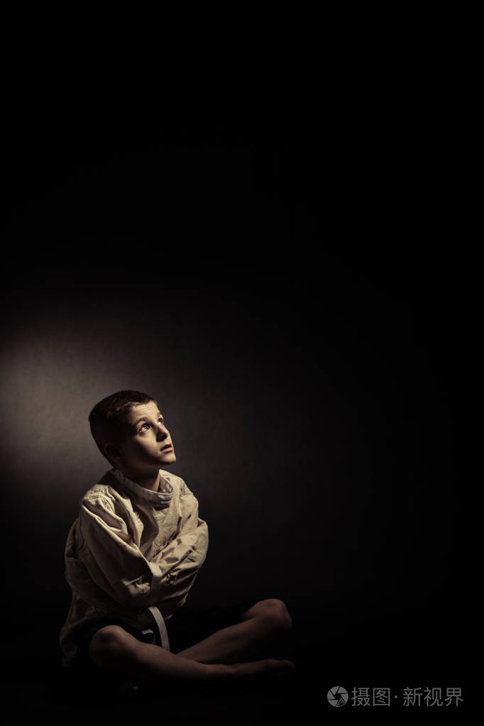 周到孤独的男孩坐在一个孤立的房间