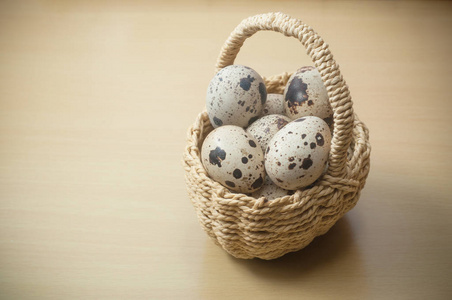 鹌鹑蛋在篮子在木桌背景