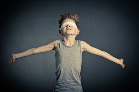 正张开双臂与蒙着双眼的小男孩照片