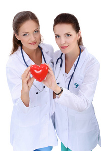 两个女医生抱着一颗红心，孤立的白色背景上