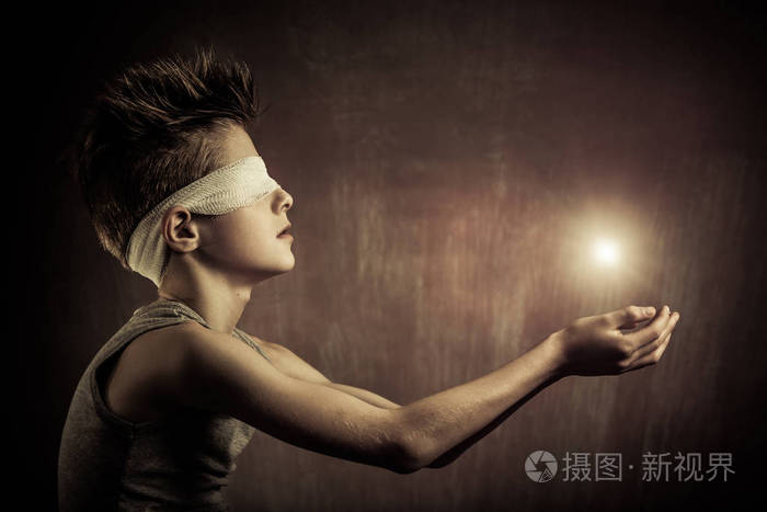 在一个失明的男孩张开双手发光光