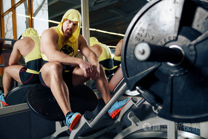 在现代的健身俱乐部休息身体健壮的年轻男人的肖像