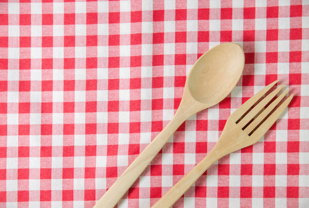 红色和白色的桌布，桌上木制的勺子