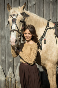 年轻漂亮的女孩正与他的马