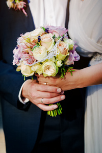 美丽的新娘花束。新娘和新郎的手的特写