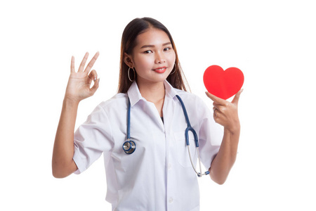 年轻的亚洲女性医生显示 Ok 签署与红色的心
