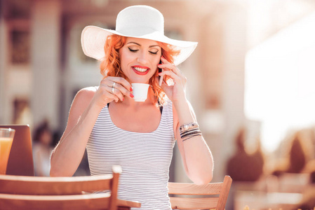 美丽的女商人, 坐在户外咖啡馆的咖啡杯和手机上交谈