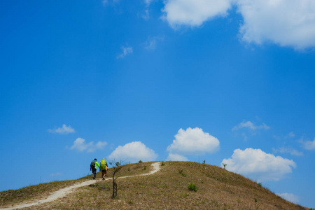 登山者在草山上。高品质的免费股票形象一组漫步在晴朗的天和蓝色的天空背景夏天陡峭的草山雄伟