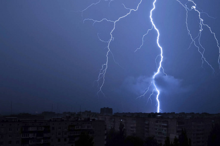 风雨的夜晚在夜晚的天空中的闪电击中房子的屋顶照片
